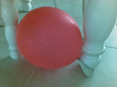 red balloon on floor by table