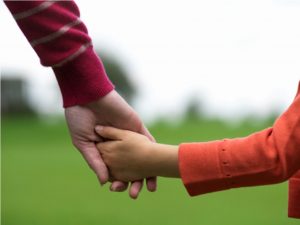 child and mom holding hands